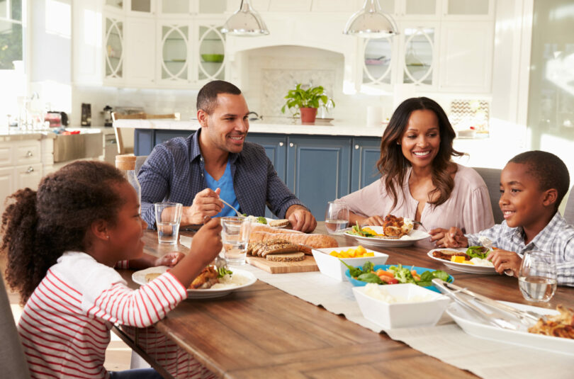 Family around the dinner table enjoying the benefits of family meals.