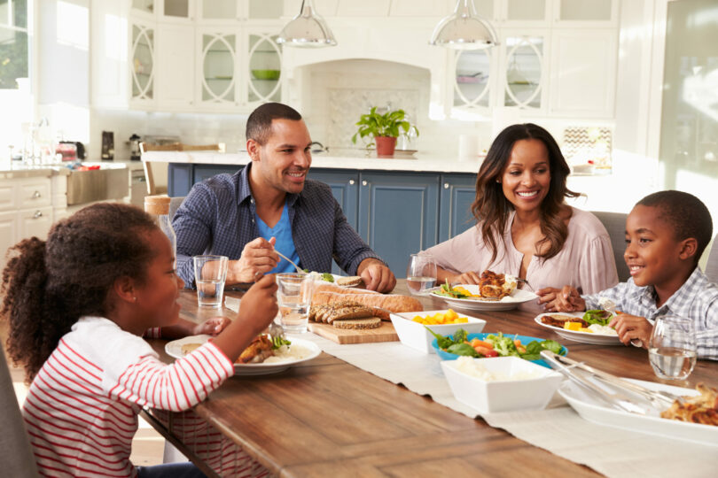 Family around the dinner table enjoying the benefits of family meals.