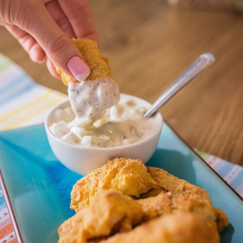 photo showing dipping homemade fish sticks into tarter sauce